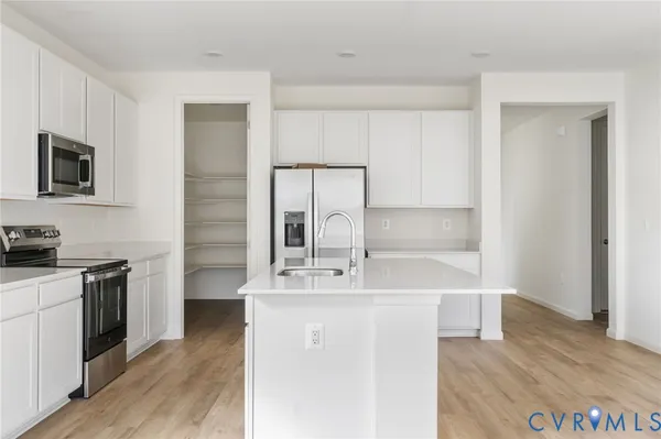 a kitchen with kitchen island a sink appliances and cabinets
