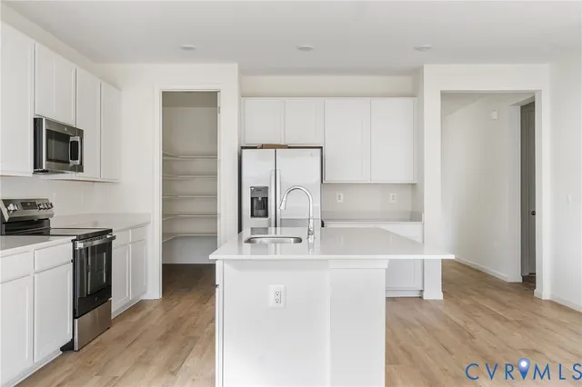 a kitchen with kitchen island a sink appliances and cabinets