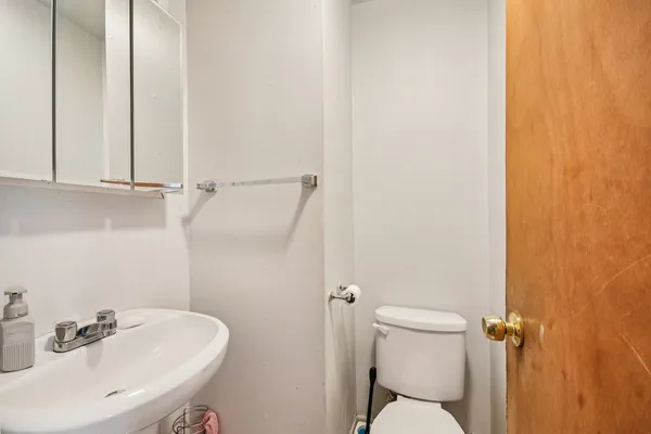 a bathroom with a sink a toilet and a mirror