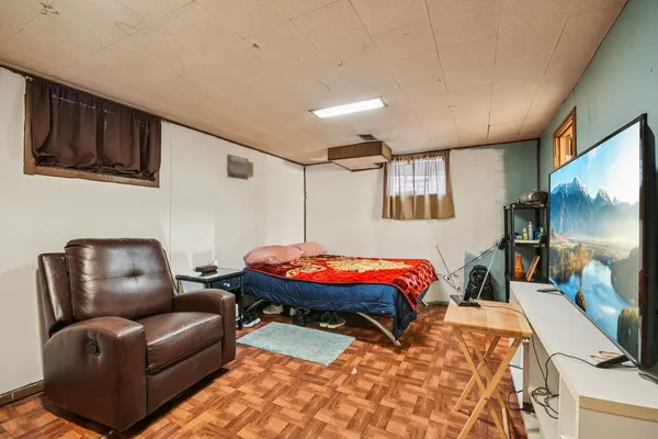 a bedroom with furniture or couch and a flat screen tv