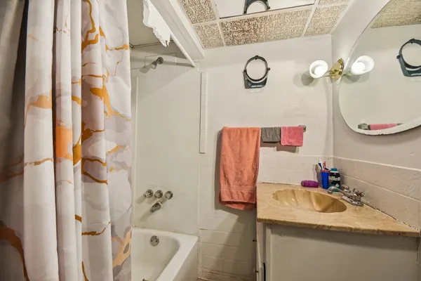 a bathroom with a granite countertop sink a mirror and shower curtain