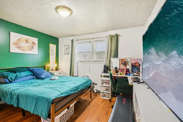 a bedroom with a bed and a dresser next to a window