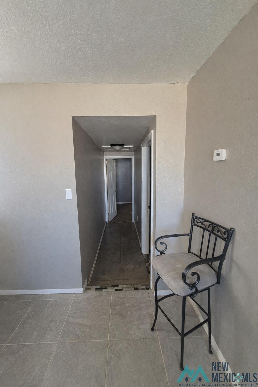 757 South Roosevelt Rd R 1/2 Portales, NM 88130 - Photo 12 of 14 Corridor featuring a textured ceiling and a textured wall