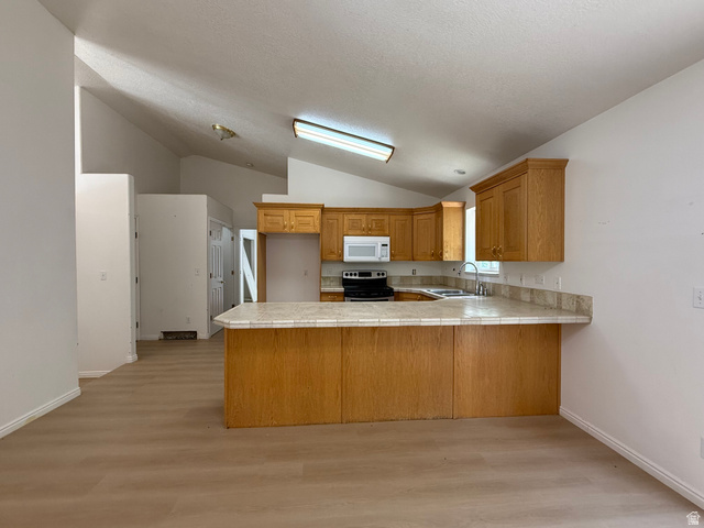 838 East Mountain Road Logan, UT 84321 - Photo 8 of 37 Kitchen featuring wood-finish cabinetry, light-toned countertops, and a built-in microwave