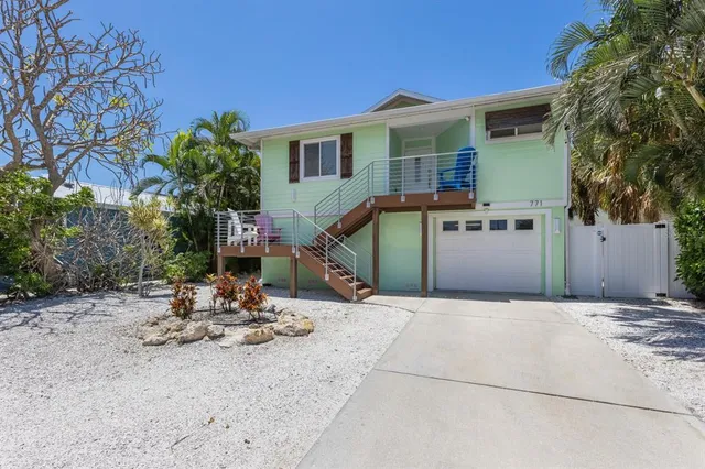 a view of a house with backyard and sitting area