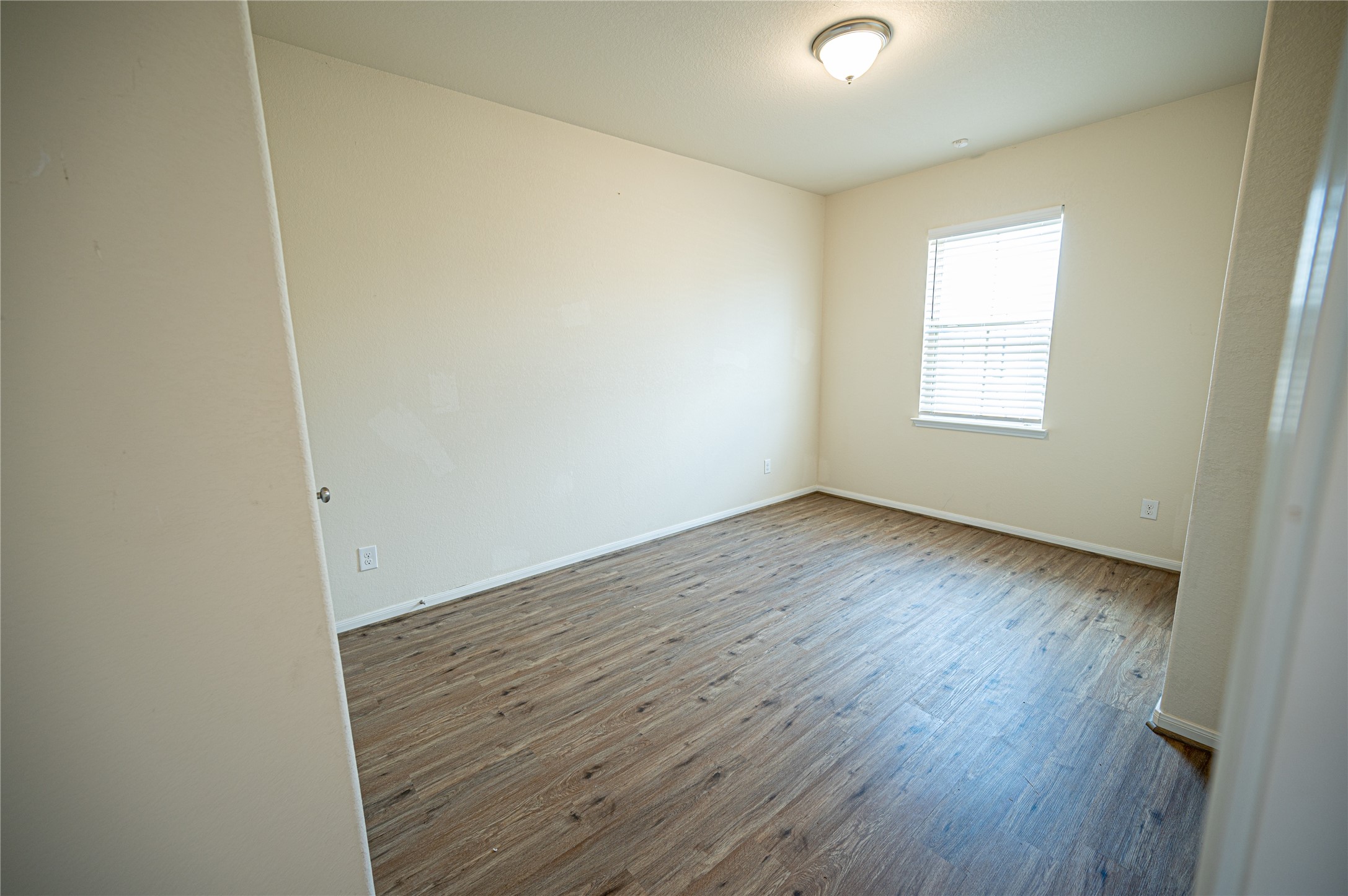 10730 Nathaniel Valley Path Houston, TX 77016 - Photo 18 of 38 an empty room with wooden floor and windows