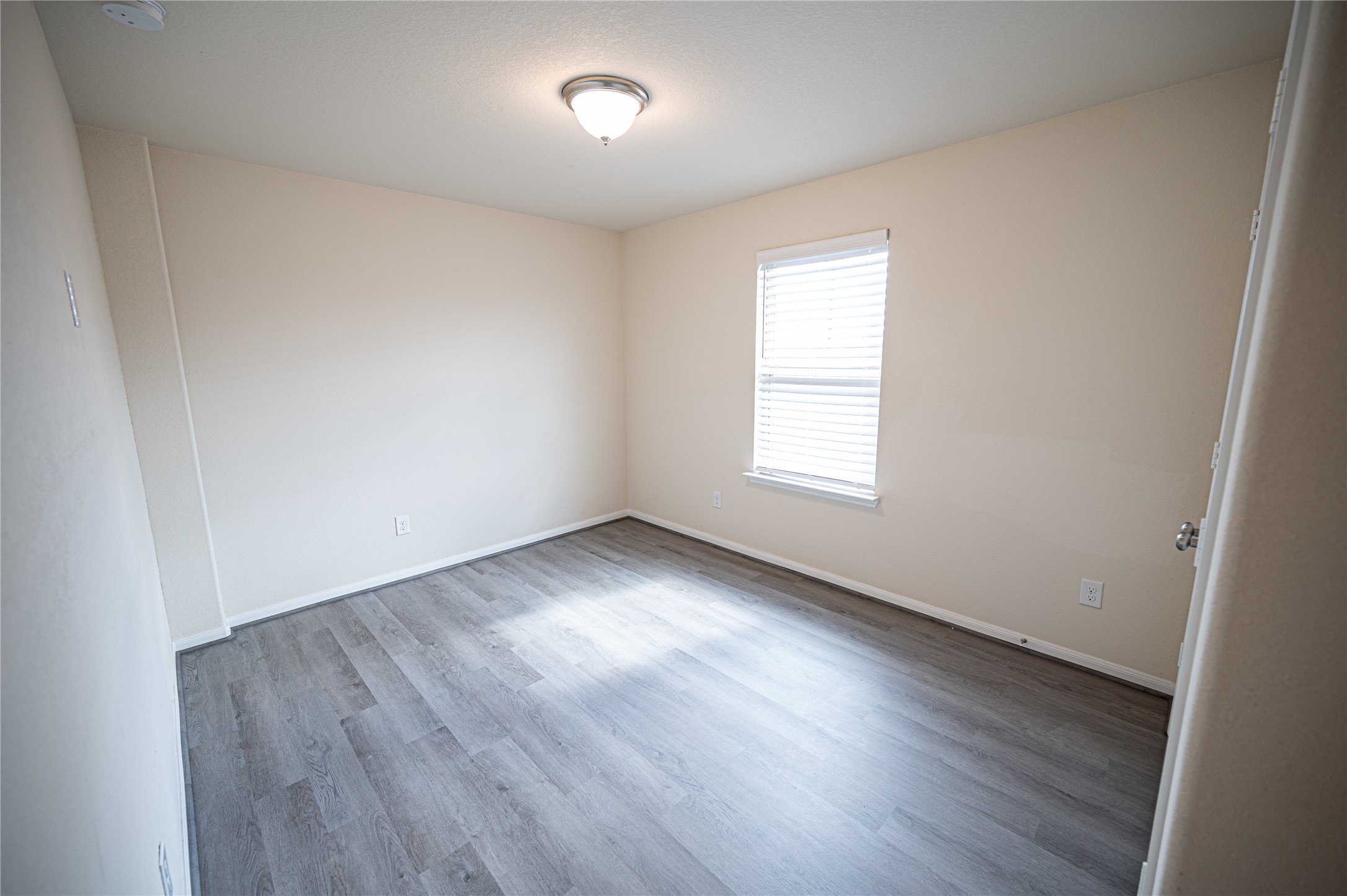 10730 Nathaniel Valley Path Houston, TX 77016 - Photo 26 of 38 an empty room with wooden floor and windows