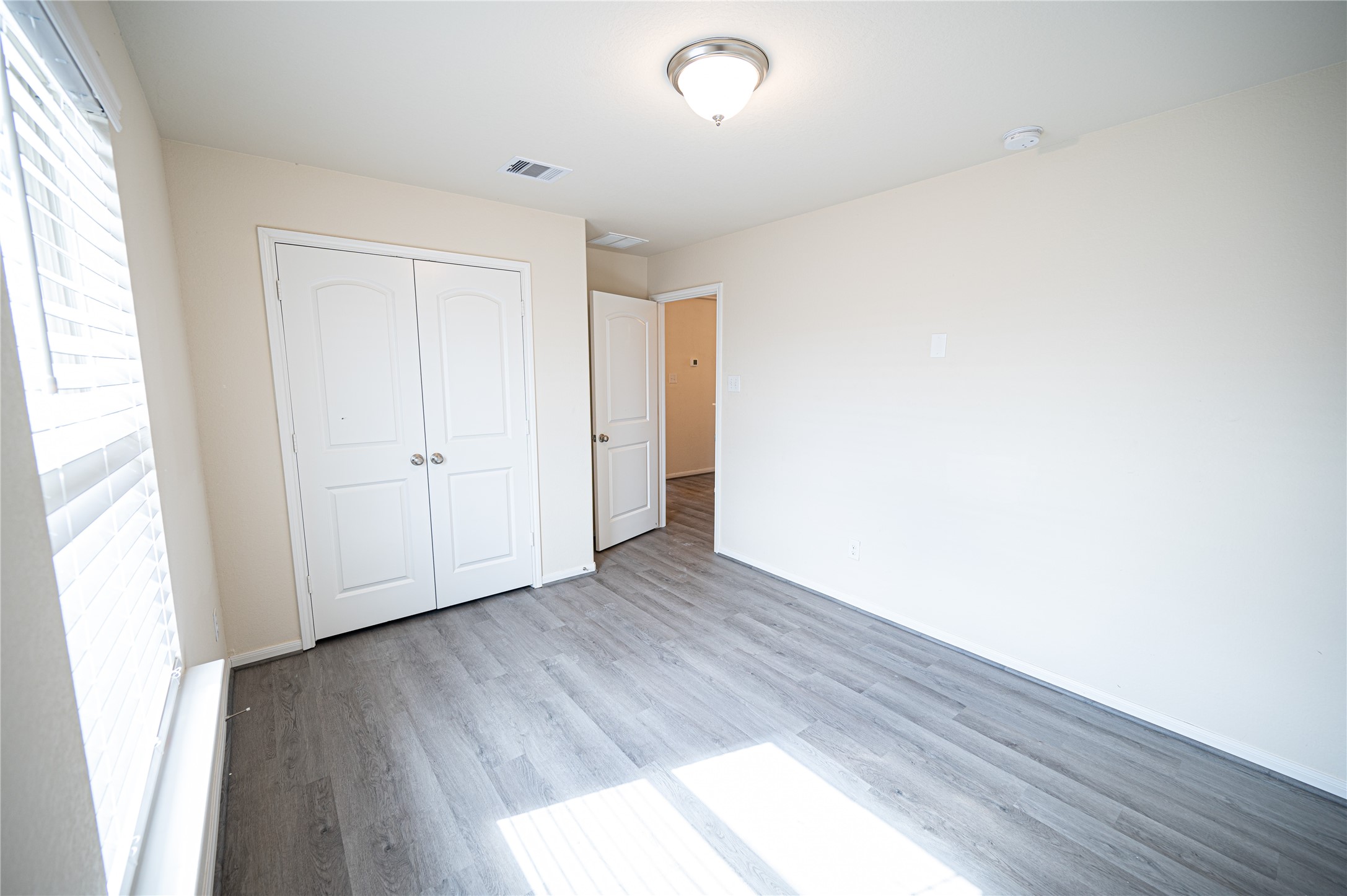 10730 Nathaniel Valley Path Houston, TX 77016 - Photo 27 of 38 an empty room with wooden floor and windows