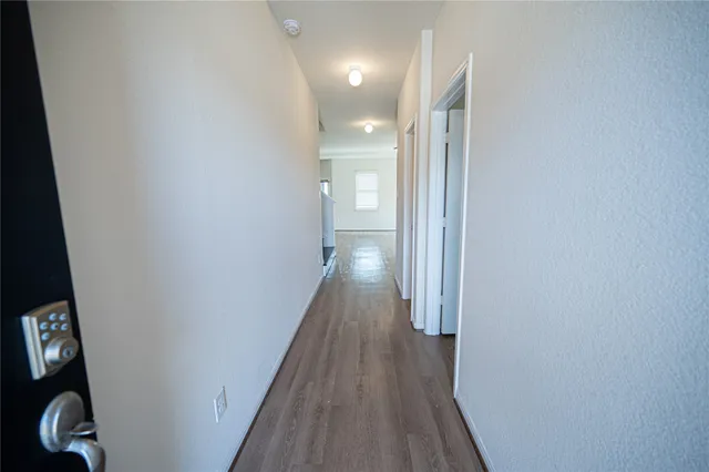 a view of a hallway with wooden floor