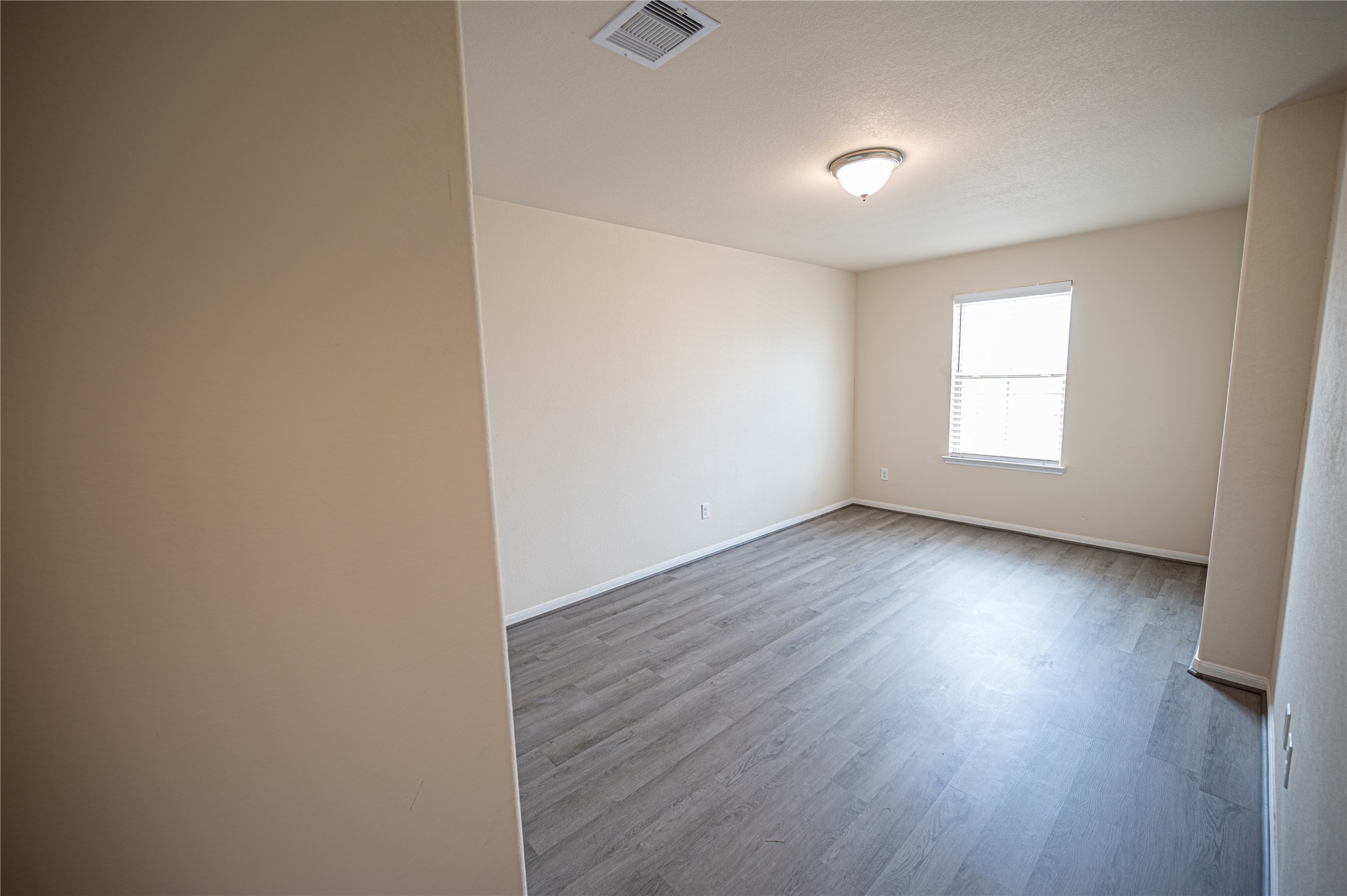 10730 Nathaniel Valley Path Houston, TX 77016 - Photo 34 of 38 an empty room with wooden floor and windows