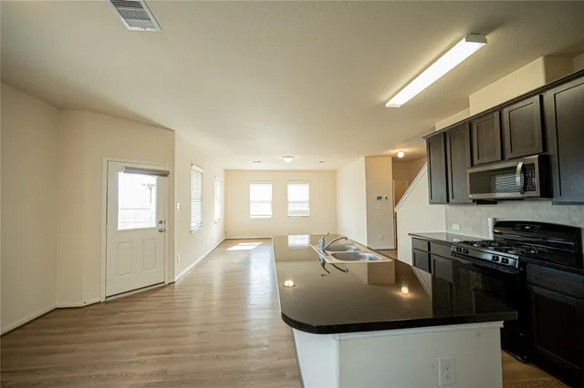 a kitchen with stainless steel appliances granite countertop a sink a stove and a refrigerator