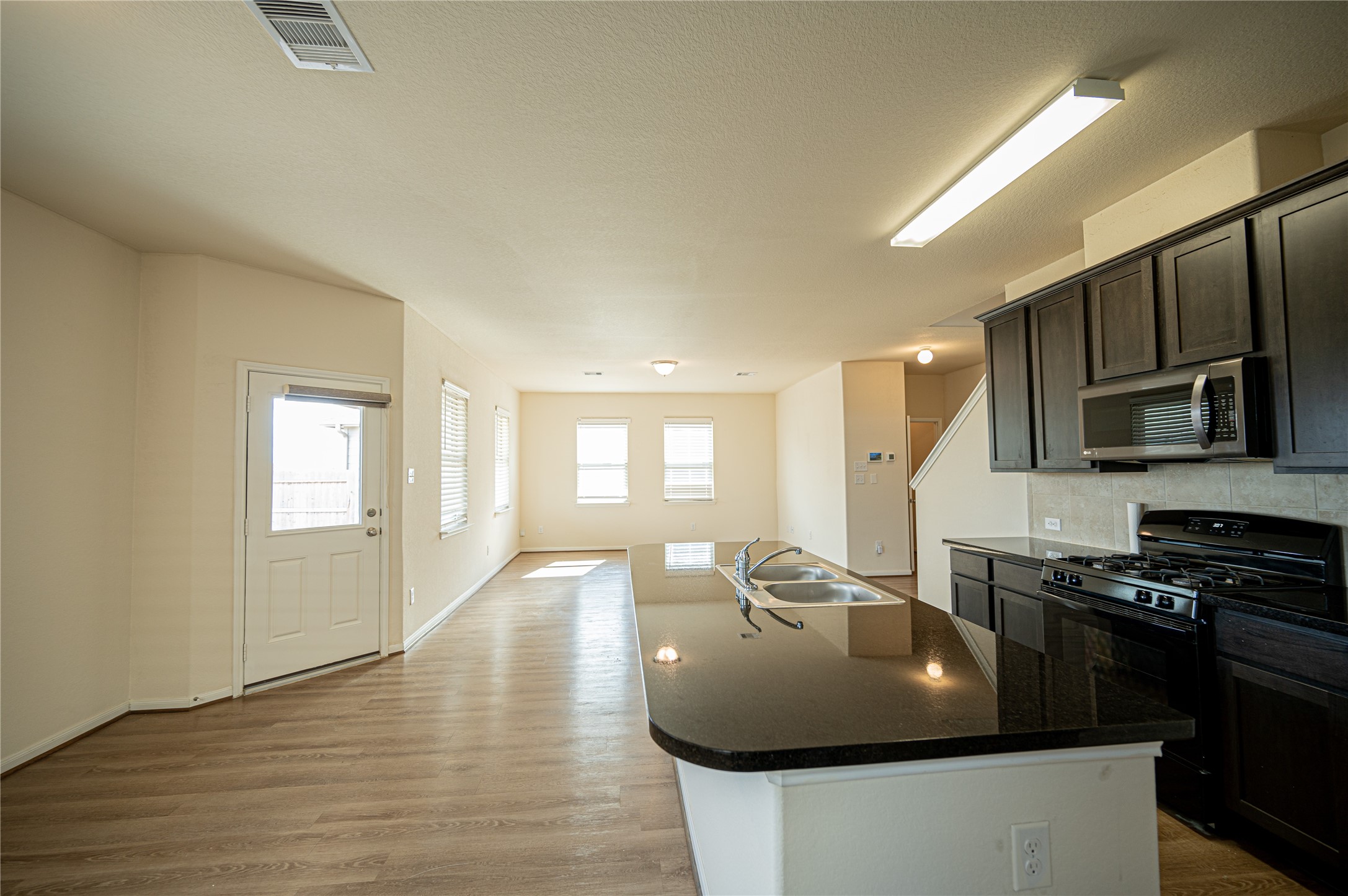 10730 Nathaniel Valley Path Houston, TX 77016 - Photo 5 of 38 a kitchen with stainless steel appliances granite countertop a sink a stove and a refrigerator