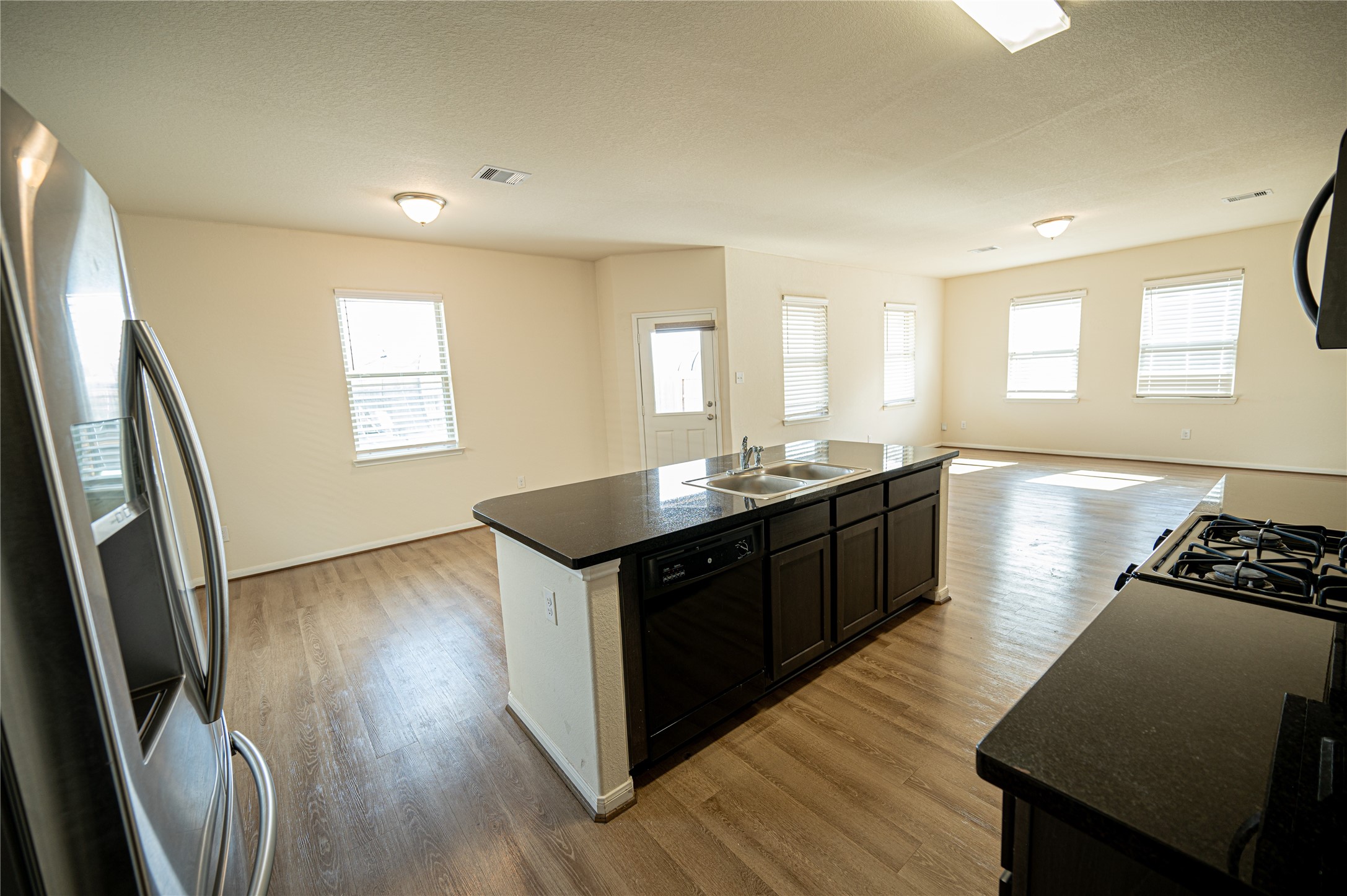 10730 Nathaniel Valley Path Houston, TX 77016 - Photo 6 of 38 a kitchen with sink cabinets and wooden floor