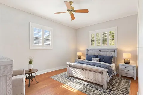 a bedroom with a bed wooden floor and a chandelier