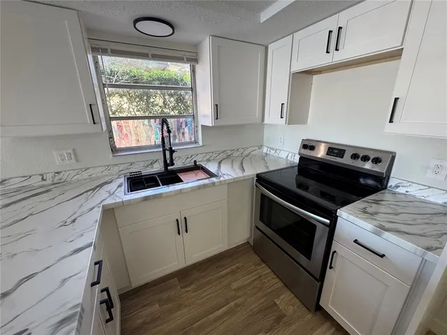a kitchen with a stove a sink and a window
