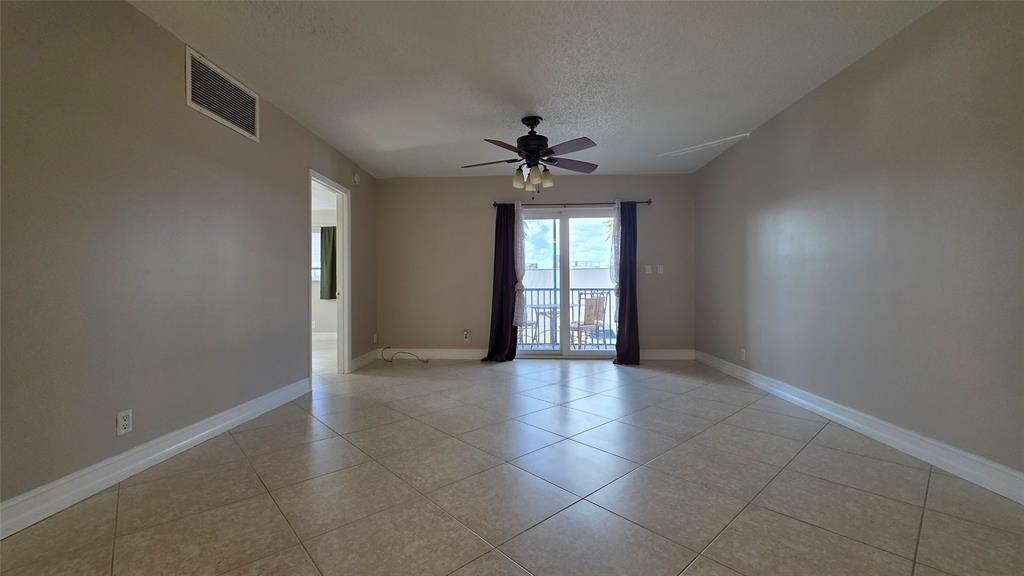 253 South Cypress Road, Unit 225 Pompano Beach, FL 33060 - Photo 14 of 23 an empty room with chandelier fan and windows