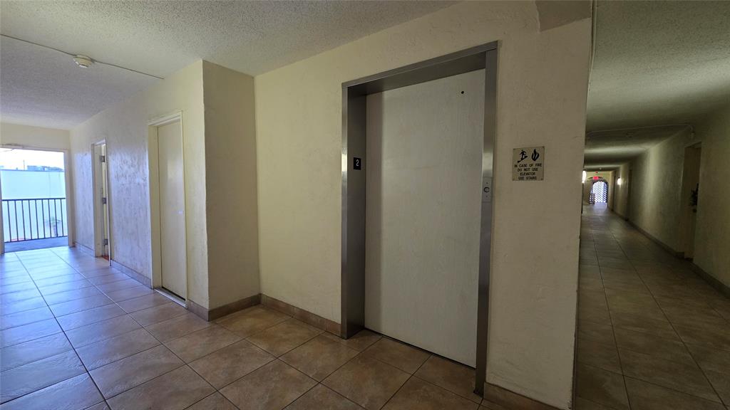 253 South Cypress Road, Unit 225 Pompano Beach, FL 33060 - Photo 18 of 23 a view of a hallway with wooden shelves
