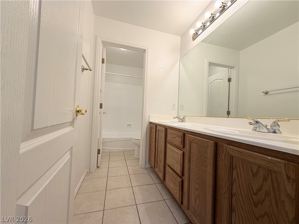 6116 Rabbit Track Street Las Vegas, NV 89130 - Photo 17 of 28 Double vanities and ample storage define this practical and comfortable bathroom.