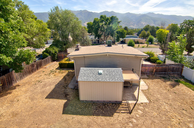 669 Colonial Avenue Layton, UT 84041 - Photo 3 of 51 Expansive backyard with a wood privacy fence, mature trees, a storage shed, and a wood deck