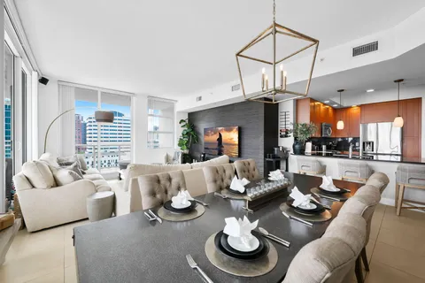 a living room with furniture kitchen view and large windows