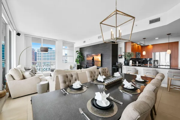 a living room with furniture kitchen view and large windows