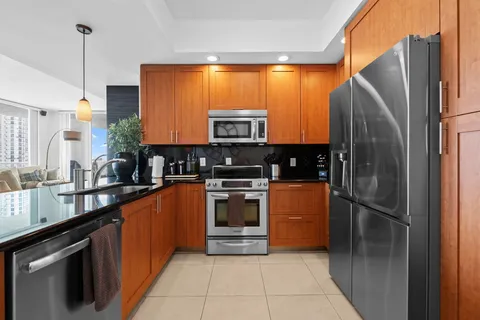 a kitchen with stainless steel appliances granite countertop a refrigerator a sink and a stove