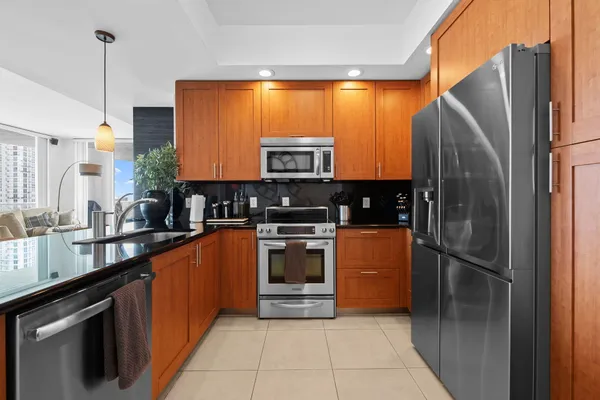 a kitchen with stainless steel appliances granite countertop a refrigerator a sink and a stove
