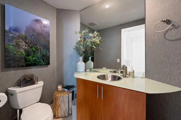 a bathroom with a sink mirror and toilet