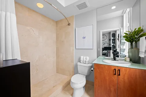 a bathroom with a granite countertop sink toilet and shower