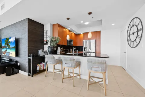 a kitchen with stainless steel appliances kitchen island granite countertop a table and chairs in it
