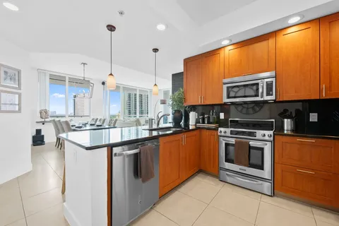 a kitchen with stainless steel appliances granite countertop a stove a sink and a microwave