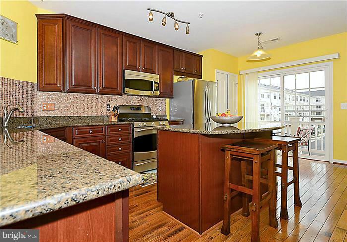22751 Verde Gate Terrace Ashburn, VA 20148 - Photo 2 of 29 a kitchen with stainless steel appliances granite countertop wooden cabinets a stove top oven a sink and dishwasher