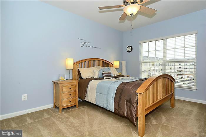 22751 Verde Gate Terrace Ashburn, VA 20148 - Photo 23 of 29 a bedroom with a bed and a chandelier