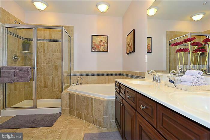 22751 Verde Gate Terrace Ashburn, VA 20148 - Photo 6 of 29 a spacious bathroom with a bathtub sink and mirror
