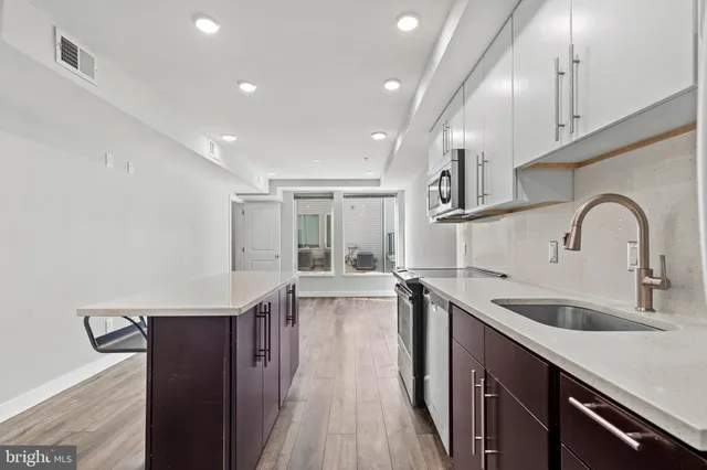 a kitchen with granite countertop a sink and wooden cabinets