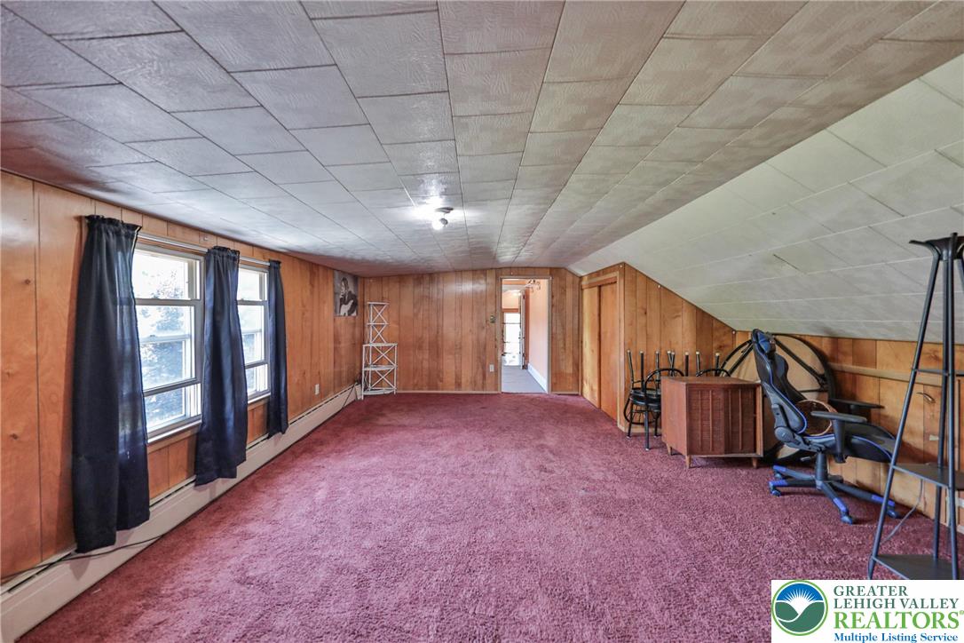 417 3rd Street Lehighton, PA 18235 - Photo 26 of 39 This versatile room, adorned with wood paneling and a plush carpet, offers adaptable space for various needs.