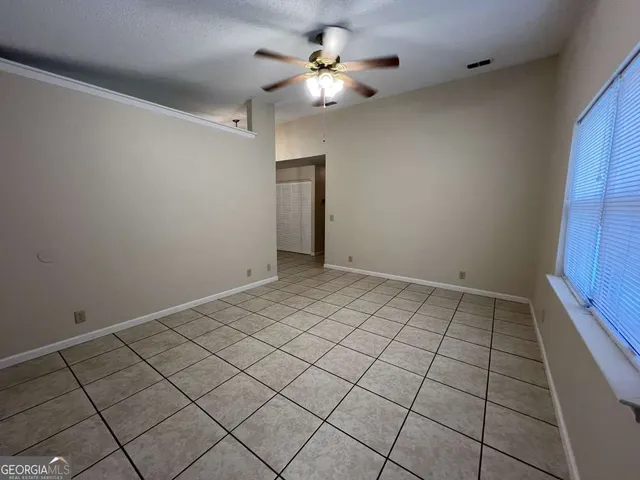 a view of an empty room and a chandelier fan