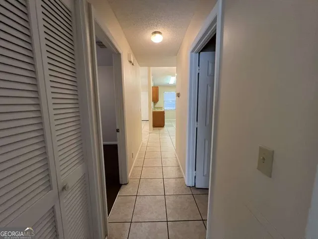 a view of a house with a yard and large tree