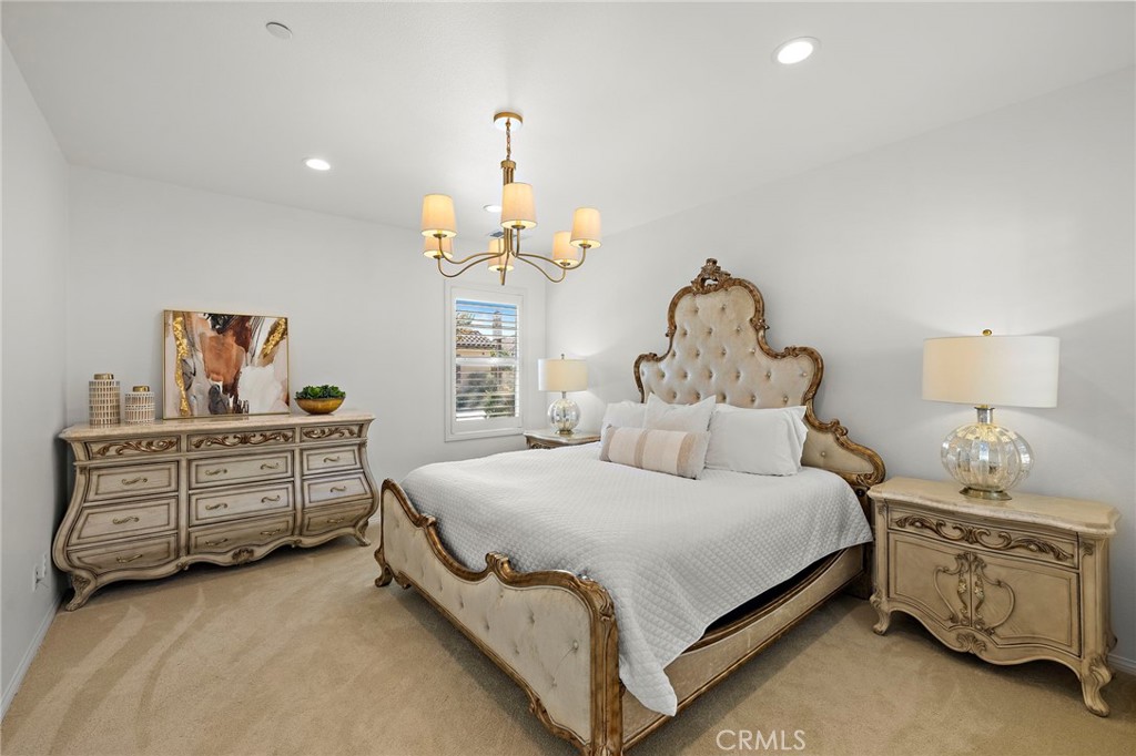 90 Galan Street Rancho Mission Viejo, CA 92694 - Photo 11 of 67 a bedroom with a bed and a chandelier