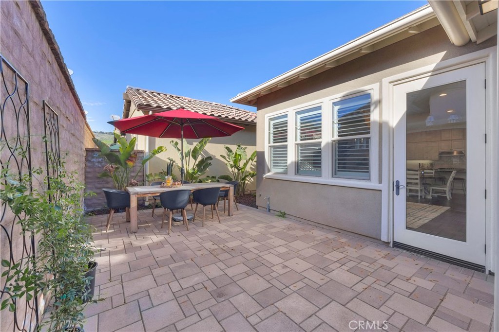 90 Galan Street Rancho Mission Viejo, CA 92694 - Photo 25 of 67 a view of a patio with a table and chairs under an umbrella with a barbeque