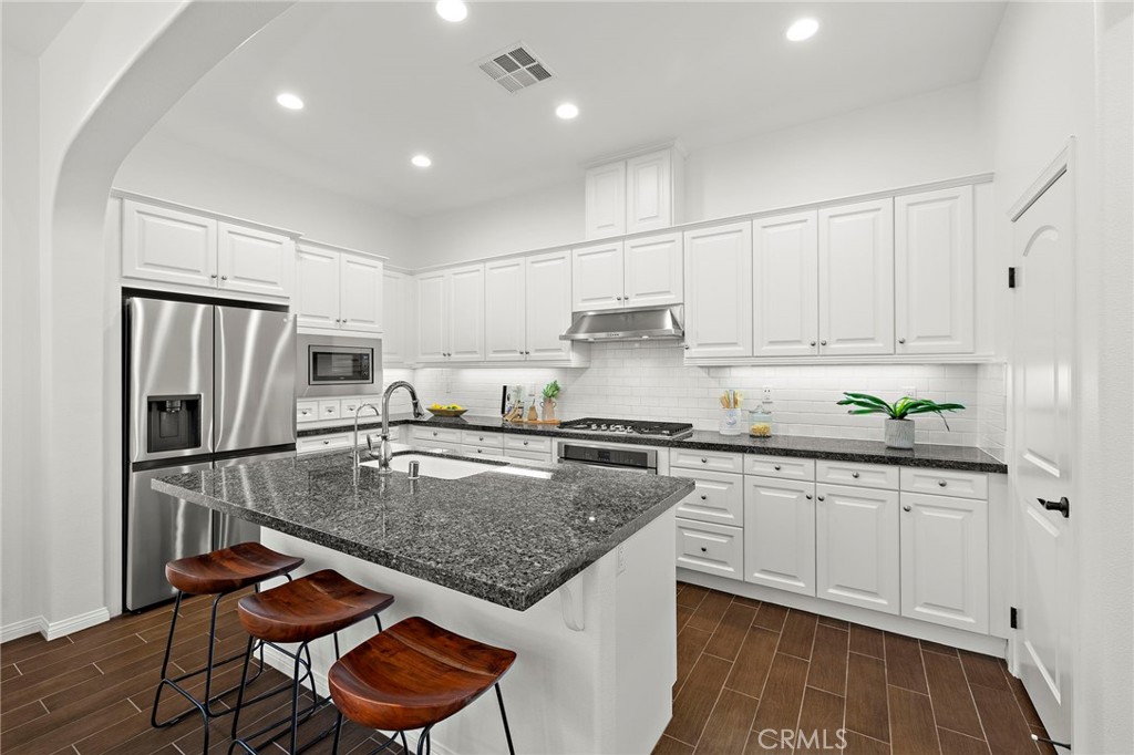 90 Galan Street Rancho Mission Viejo, CA 92694 - Photo 8 of 67 a kitchen with stainless steel appliances granite countertop a sink refrigerator and cabinets