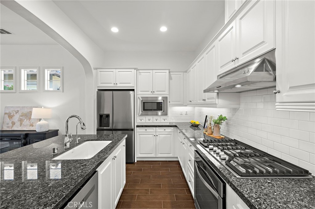 90 Galan Street Rancho Mission Viejo, CA 92694 - Photo 9 of 67 a kitchen with stainless steel appliances granite countertop a sink stove and refrigerator