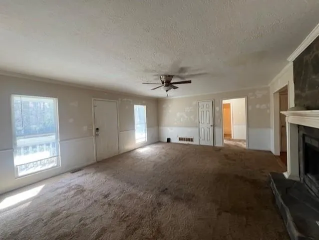 a view of empty room with fireplace and fan