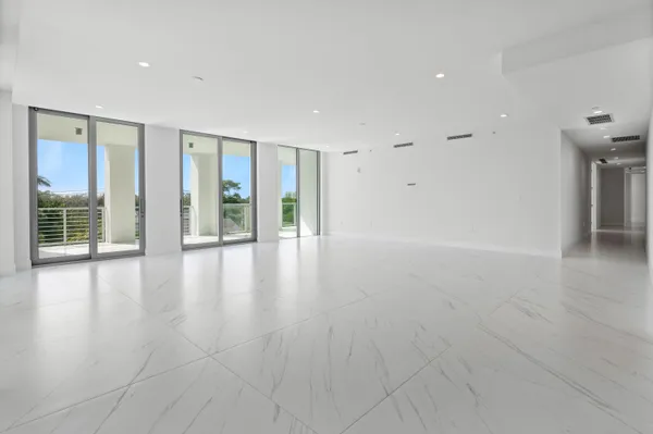 a large white kitchen with granite countertop a large window