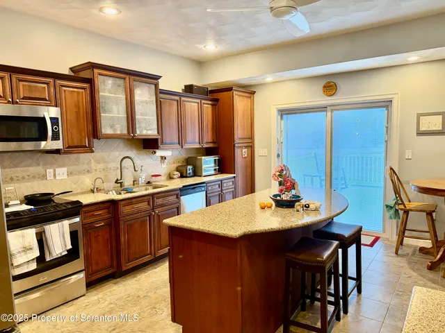 a kitchen with a sink a microwave and chairs