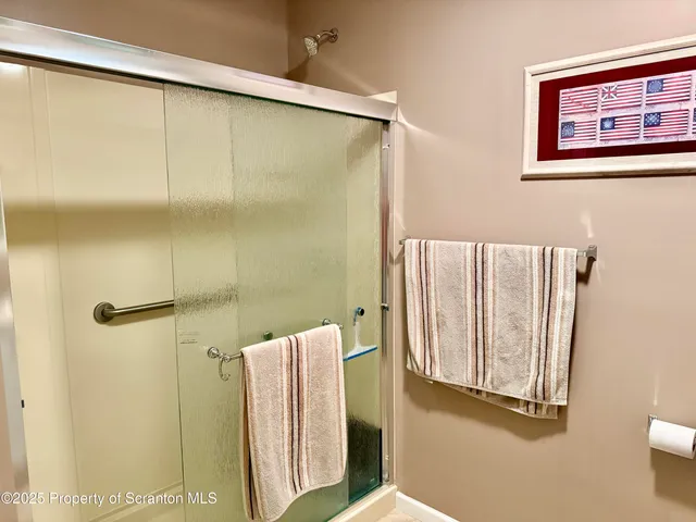 a bathroom with a shower and a glass door