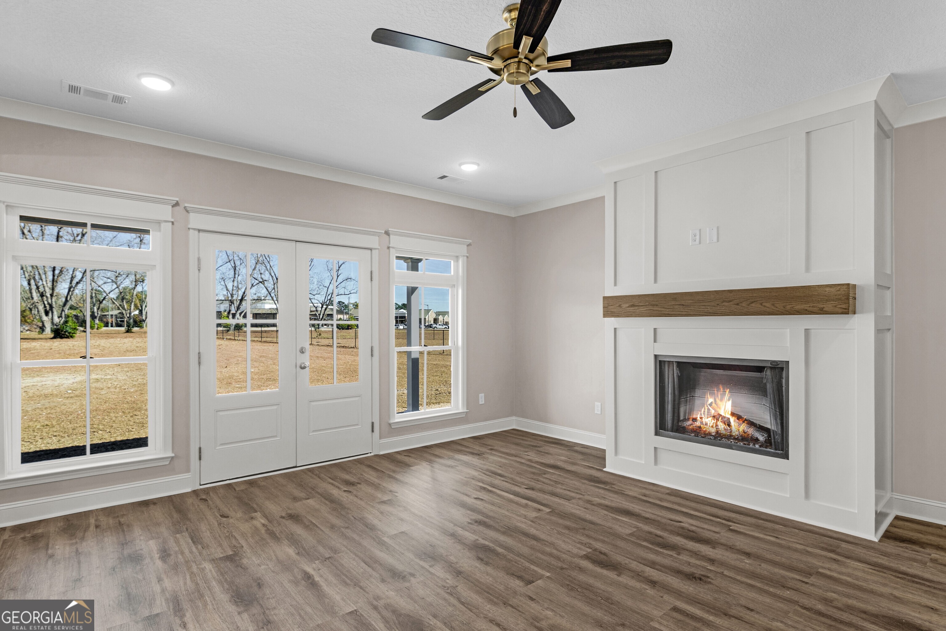 7 Honeysuckle Way Claxton, GA 30417 - Photo 6 of 31 a view of an empty room with wooden floor fireplace and a window