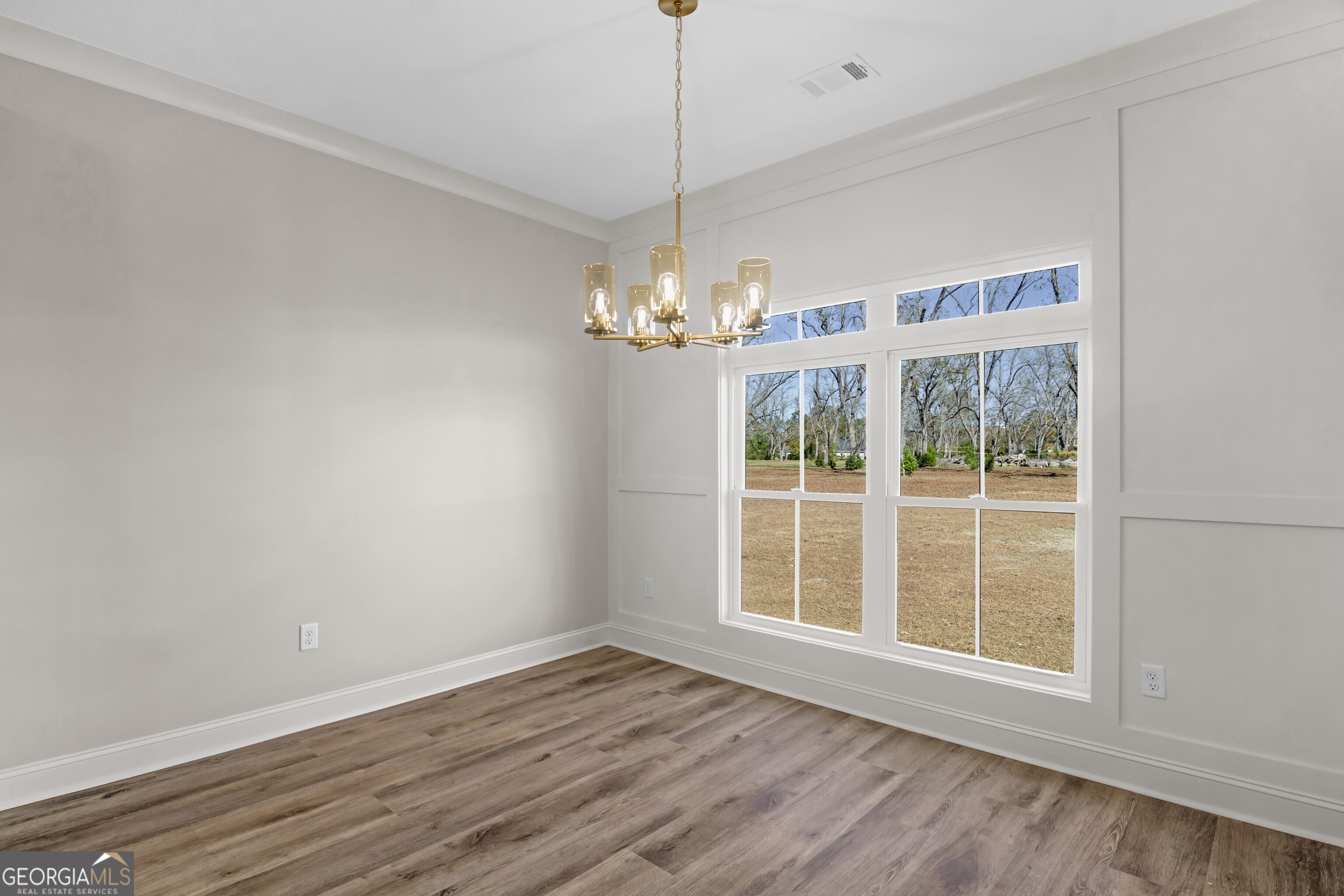 7 Honeysuckle Way Claxton, GA 30417 - Photo 7 of 31 a view of an empty room with wooden floor and a window