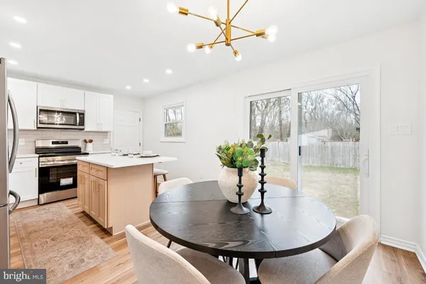a kitchen with a table chairs a sink and appliances