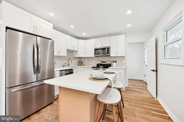 a kitchen with stainless steel appliances a refrigerator stove microwave and sink